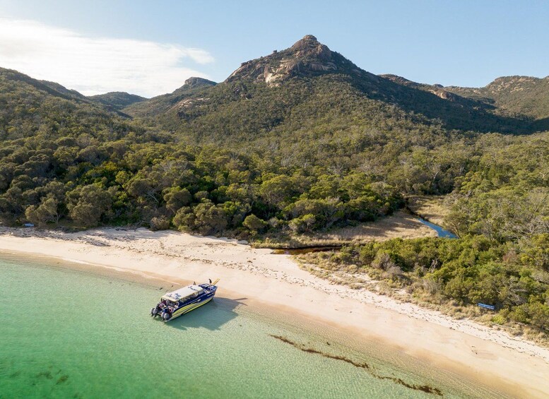 Ein Boot am Strand, im Hintergrund ein Berg. 2
