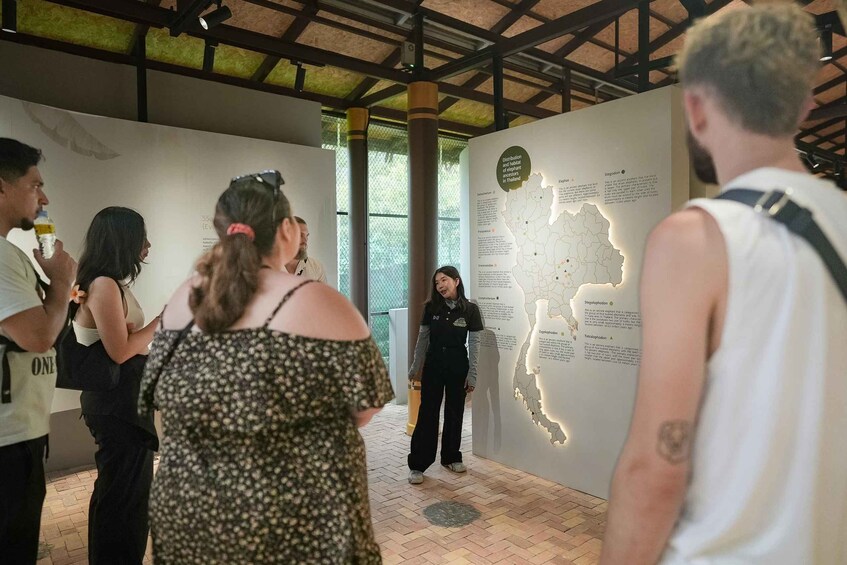 A group of people at an indoor exhibit with a map and informational panels. 5