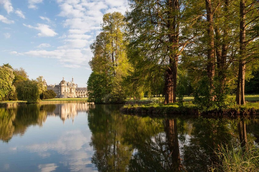 A serene lake with reflections of trees and a grand building in the background. 3