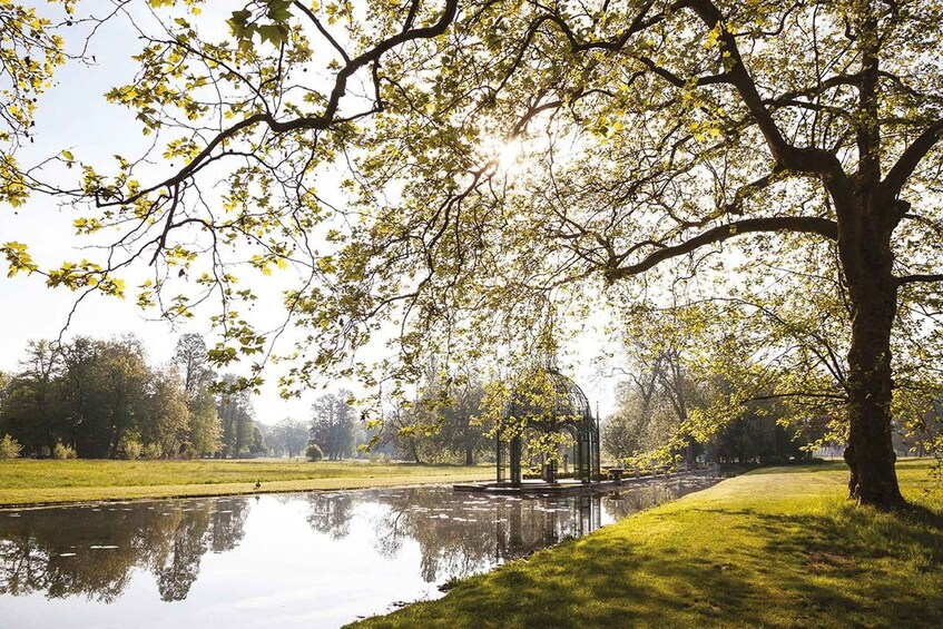 A park with a large tree, a pond, and a gazebo. 5
