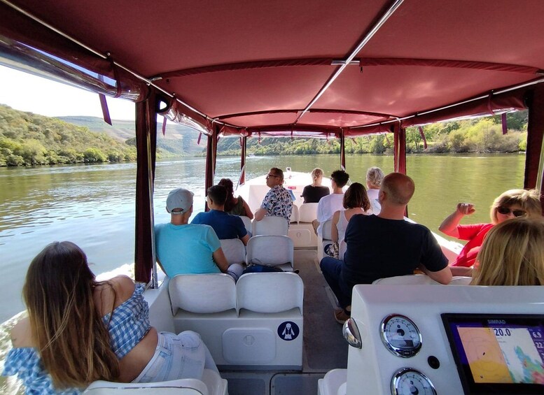 Un grupo de personas en un bote, con un río y vegetación al fondo. 1