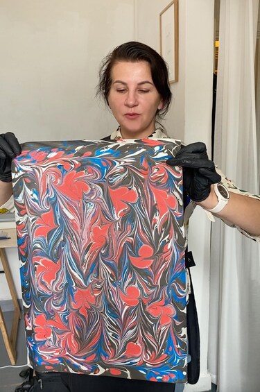 Une personne tenant un grand tissu coloré orné d’un motif floral. 5