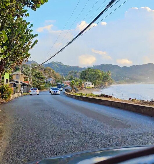 Una carretera costera con vehículos, casas y una playa. 4