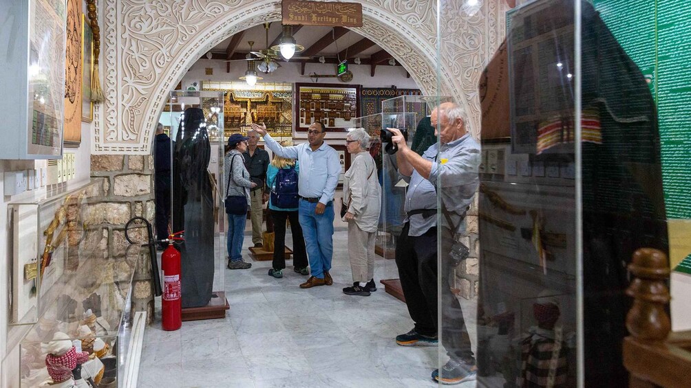 Interior de museo con arquitectura ornamentada, vitrinas de cristal y visitantes observando las exhibiciones. 3