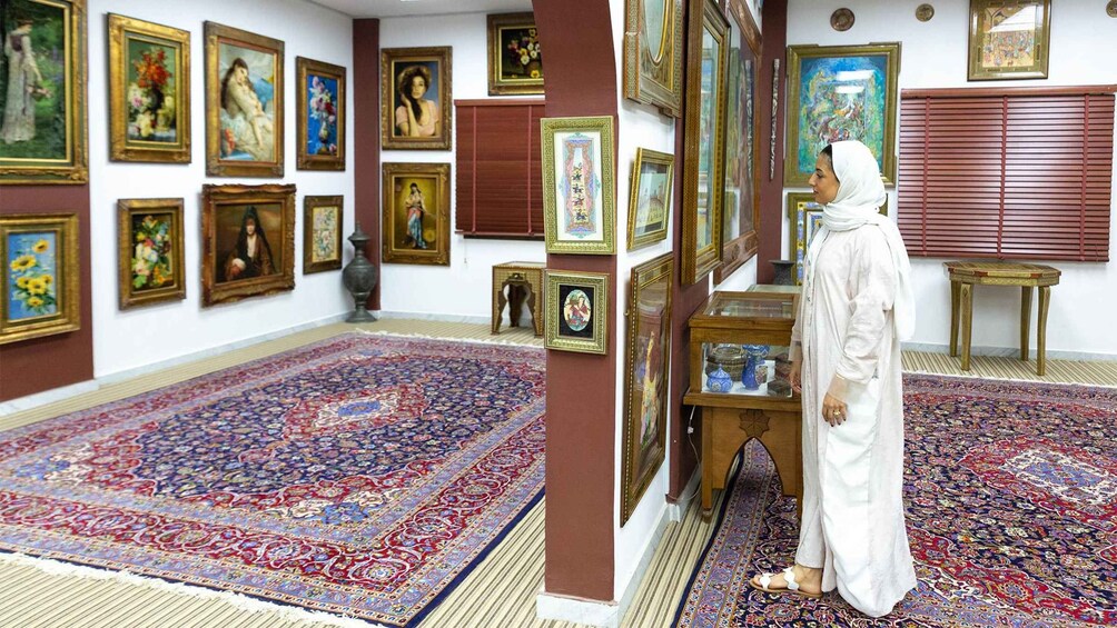 Una habitación con una alfombra grande y elaborada, y varias obras de arte enmarcadas en las paredes. 2