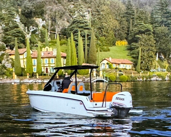 Un barco motor blanco con asiento naranja y motor 'SELVA' sobre aguas tranquilas. 2