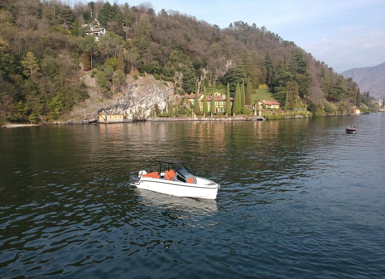 Un lago tranquilo con un bote, rodeado de colinas y casas. 4