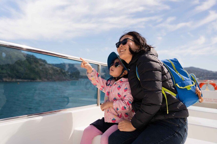 Una mujer y un niño en un bote, señalando el agua. 5
