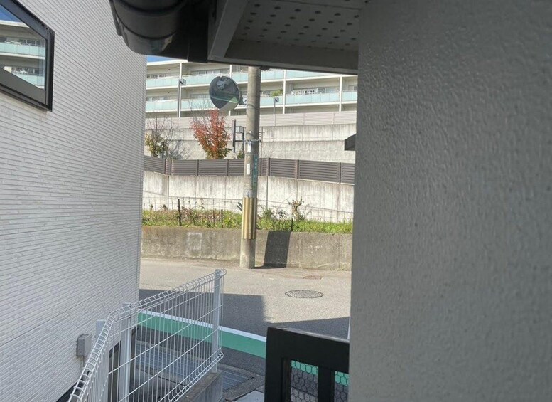 Un edificio con una valla metálica, una calle y un muro de concreto con una pasarela para peatones. 4