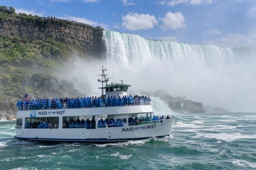 A boat named 'MAID OF THE MIST' with passengers, sailing near a waterfall. 1