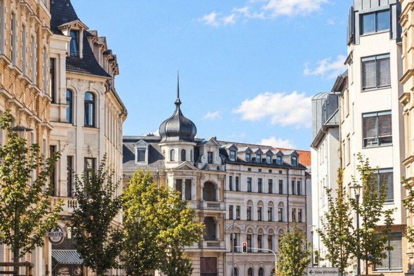 A historic building with a dome and classical architecture, surrounded by modern buildings and trees. 5