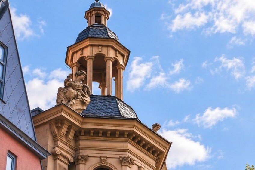 A building with a classical architectural style, featuring a bell tower with statues and intricate carvings. 3