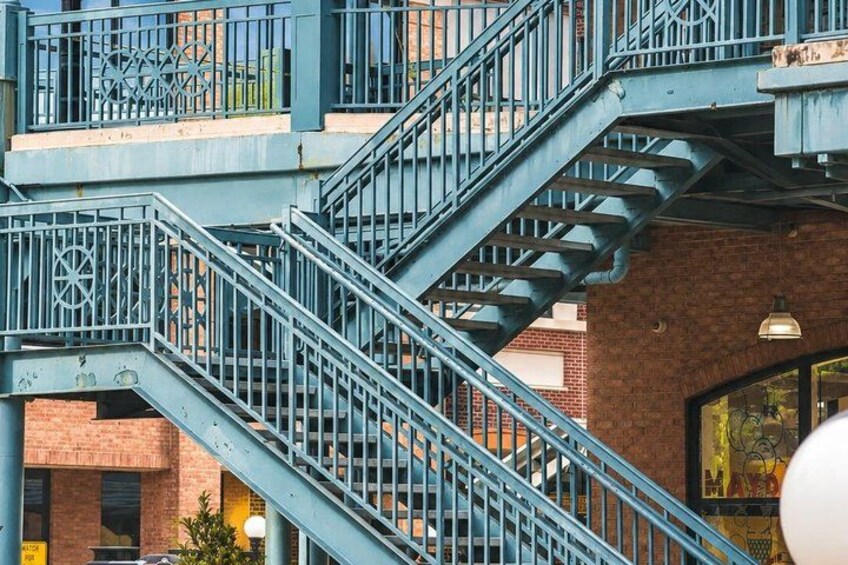 A multi-level metal staircase with railings, connecting different floors of a building with brick walls. 4