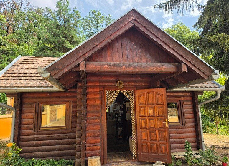 A rustic wooden cabin with a gabled roof, a decorative door, and a window. 3