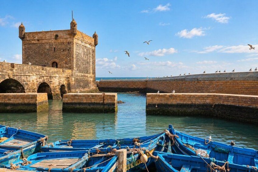 A stone tower, calm water, and blue boats. 4
