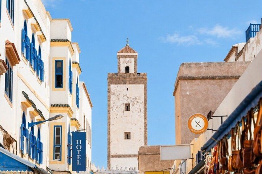 A street with buildings, a clock, and a sign that says 'HOTEL'. 3