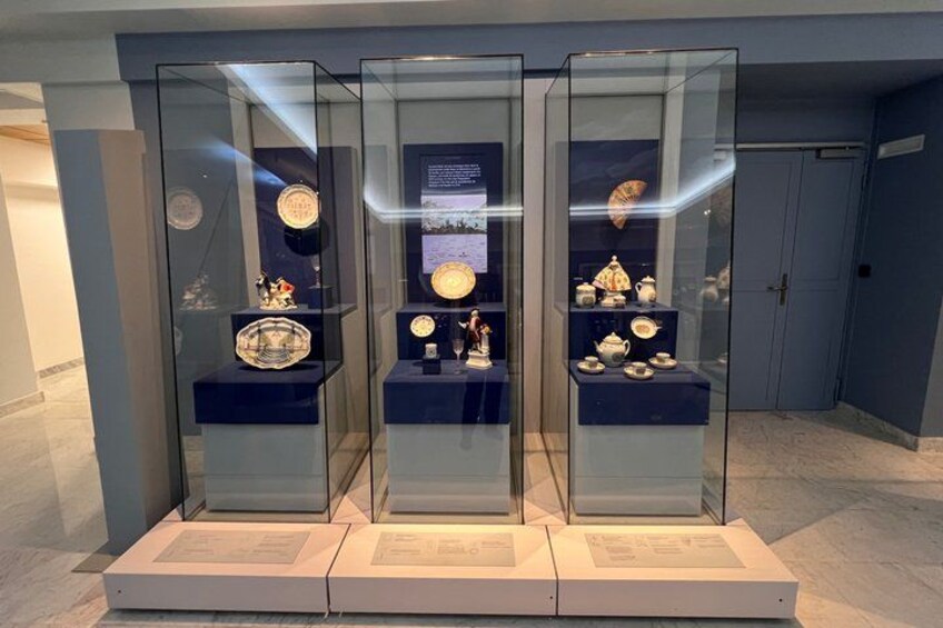 A museum display with glass cases containing porcelain items. 4