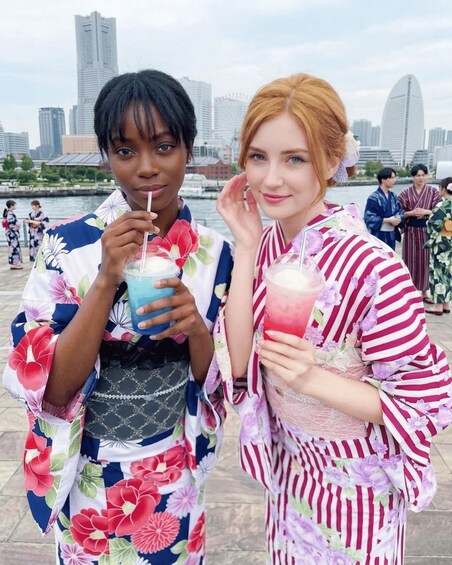 Two people in traditional Japanese attire holding drinks. 1