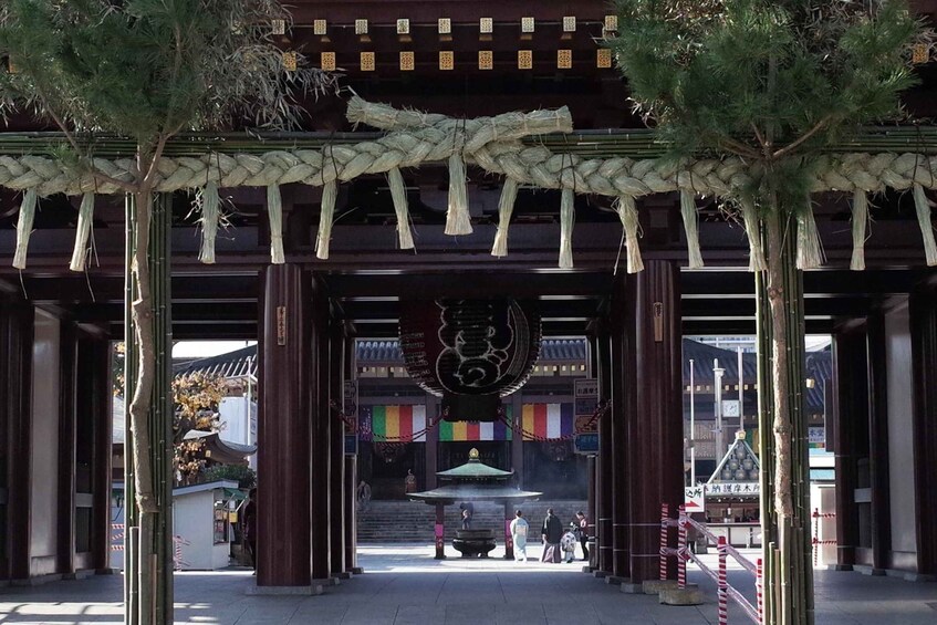 Un torii japonés tradicional con una cuerda colgante y un gran emblema negro. 2