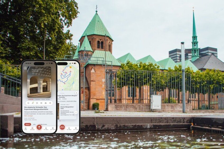 A historic building with a green roof and a church steeple in the background. 1