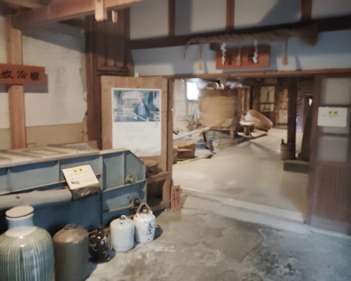 A traditional Japanese interior with tatami flooring, a wooden beam structure, and various ceramic items. 4