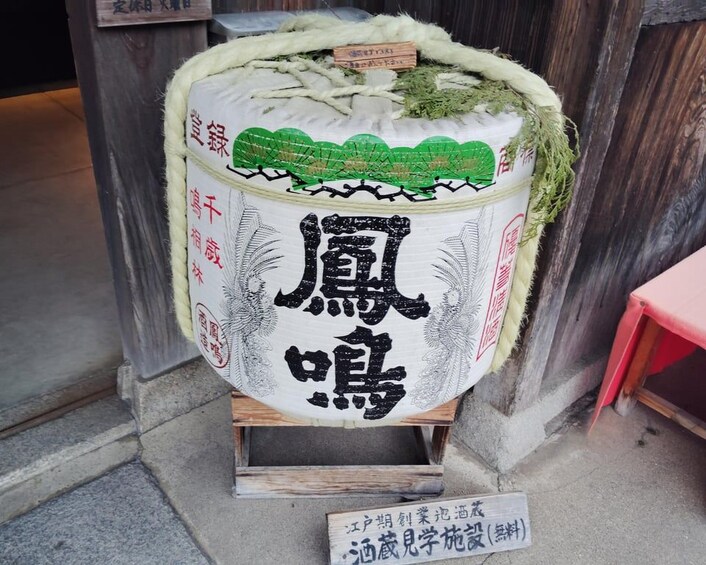 A traditional Japanese sake barrel with calligraphy and a label. 3