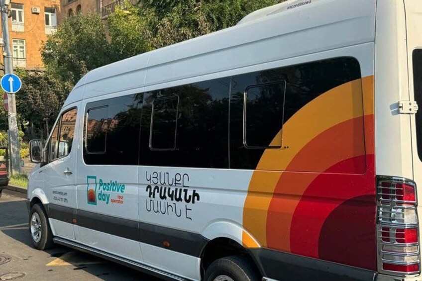 A white van with colorful graphics and text on its side, parked on a street. 2