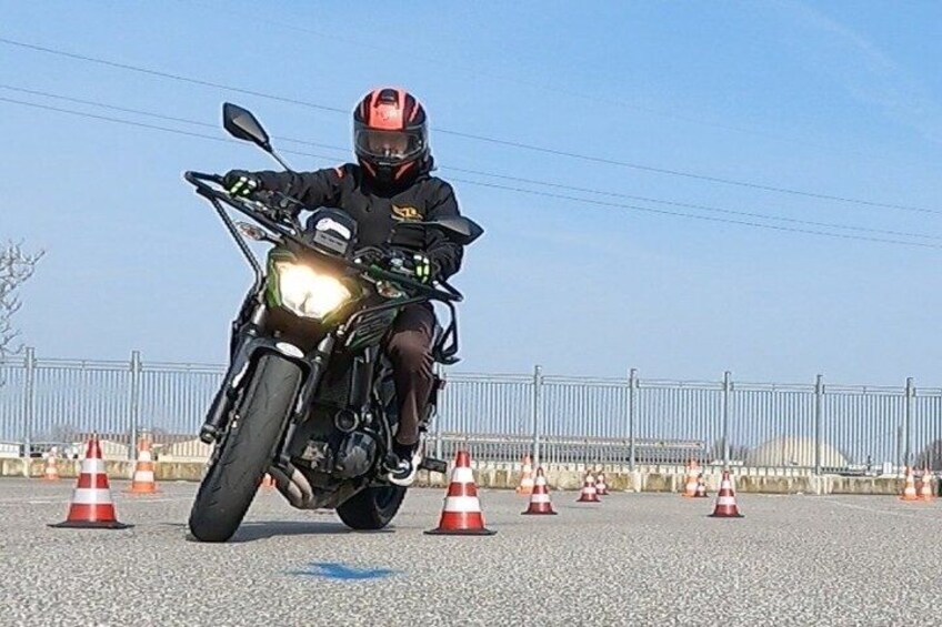 A person riding a motorcycle on a road with traffic cones. 3