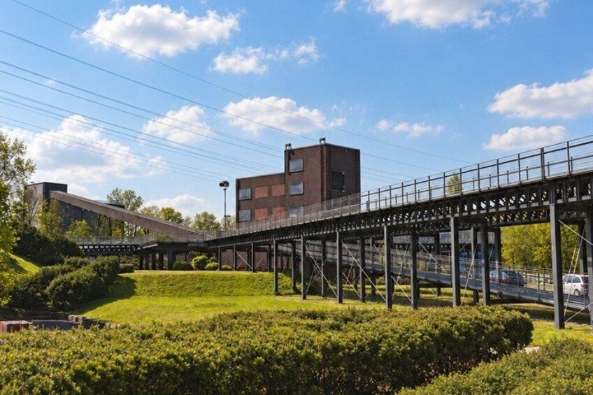 A pedestrian bridge, a grassy area, and a building. 5