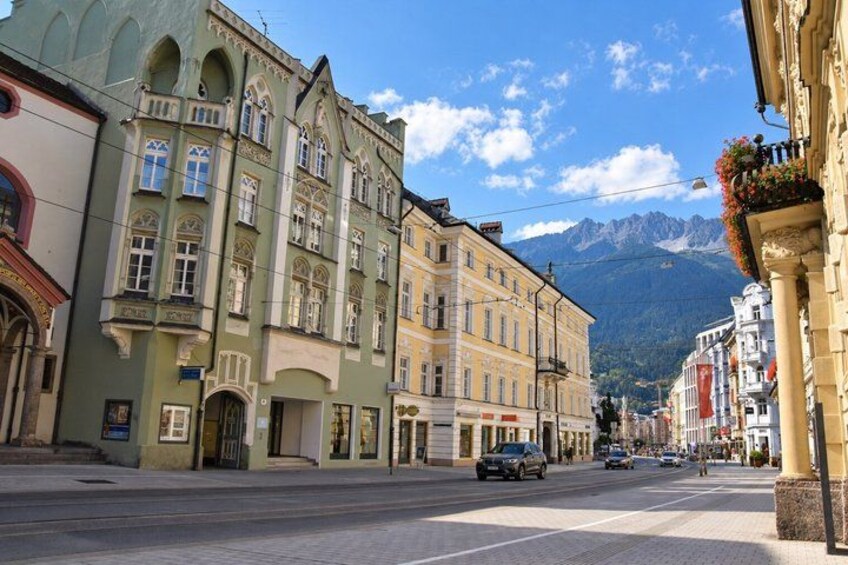 A street with historic buildings, a mountain in the background, and a clear sky. 2