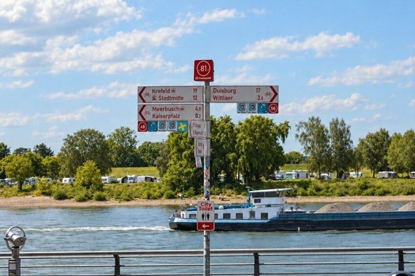 A river with a boat, a signpost with directions, and a clear sky. 2