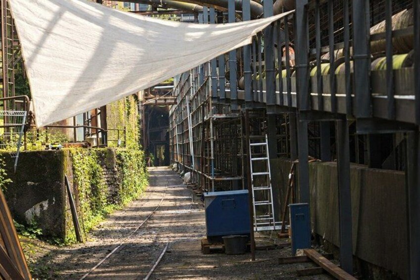 A railway track with a white canopy, metal structures, and a ladder. 5