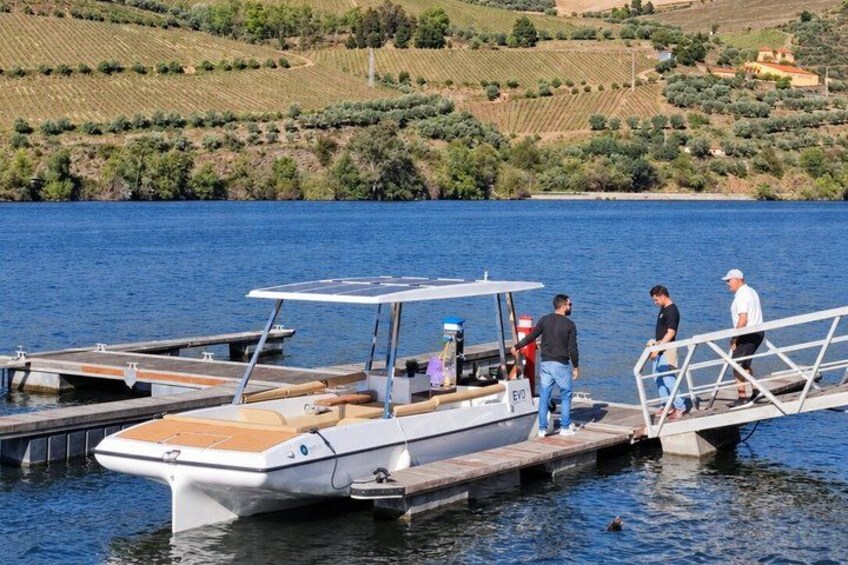 A boat docked at a pier with people standing on it. 2
