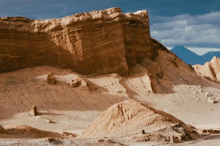 A desert landscape with prominent rock formations and a distant mountain range. 5