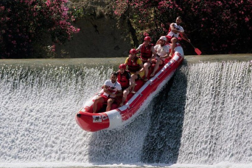 A group of people in a red and white raft navigating a water slide. 3