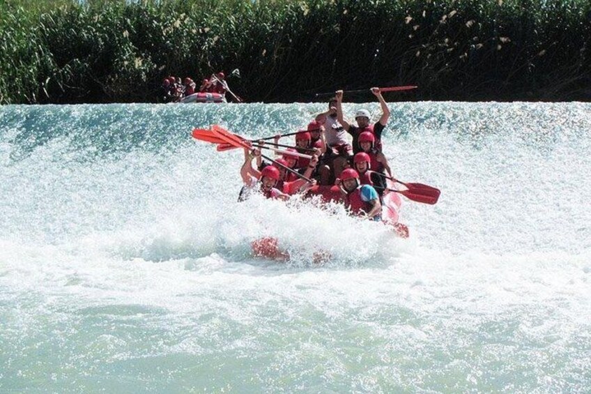 A group of people in a red raft navigating through a body of water. 2