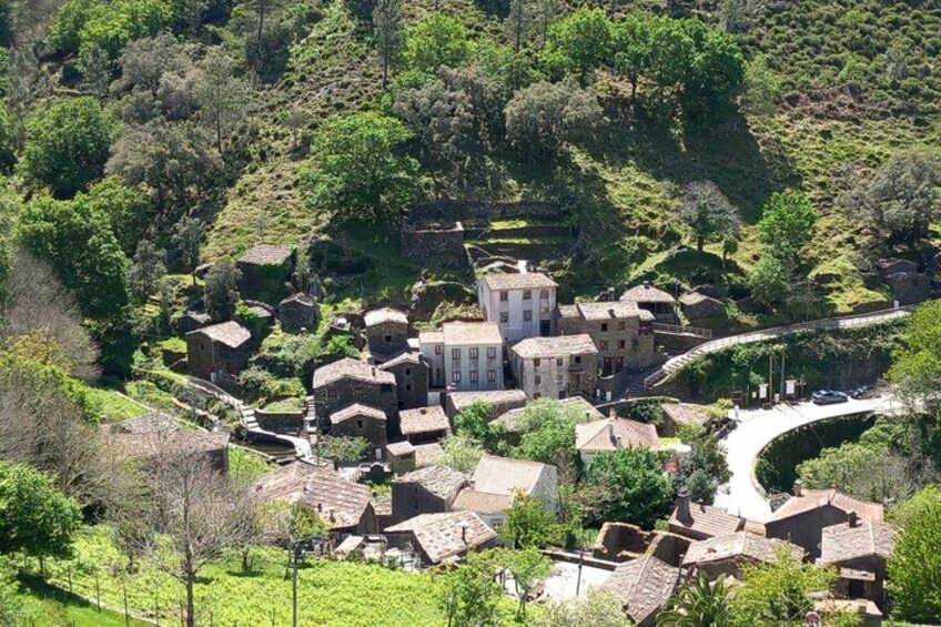 A village with stone houses, a central building, and a winding road. 2