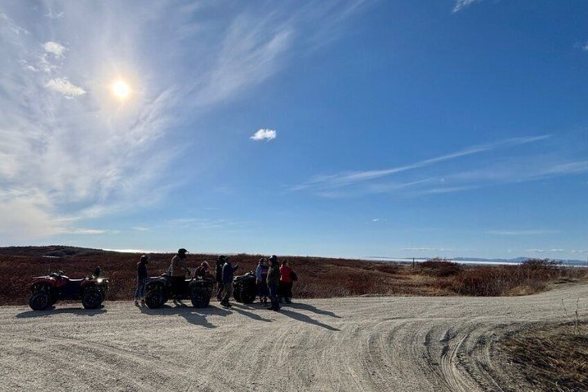 A group of people on a dirt road with a clear sky and the sun shining. 3