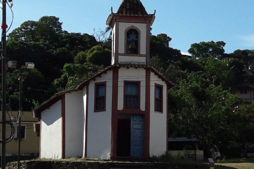 A small church with a bell tower, surrounded by trees. 4