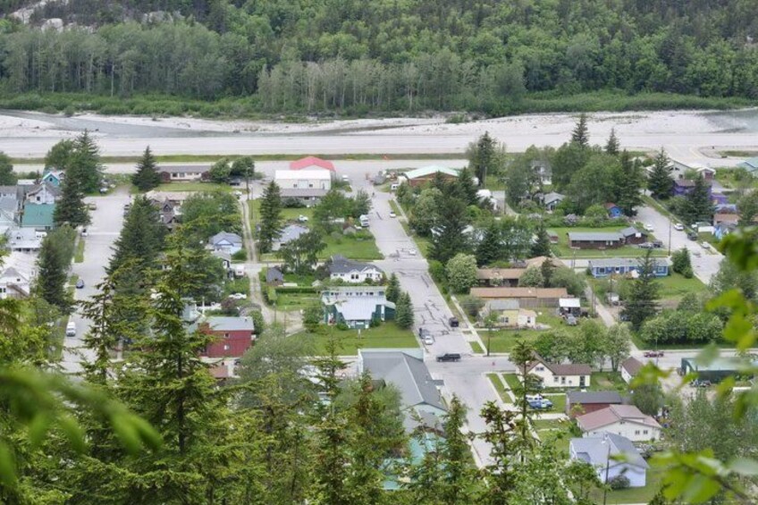 A residential area with houses, roads, and a beach in the background. 2
