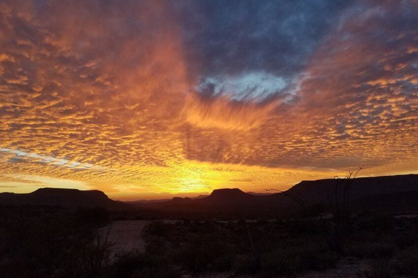 A sunset over a mountainous landscape with a clear sky. 3