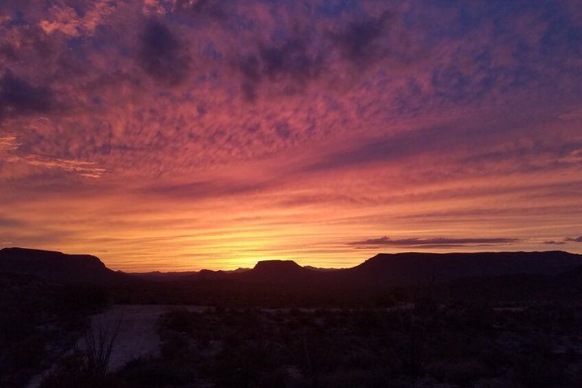A sunset over a mountainous landscape with a clear sky. 2