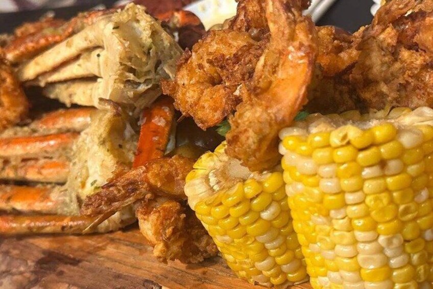 A meal with fried seafood and corn on the cob. 4