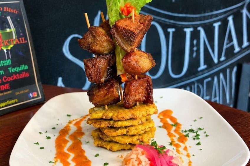 A plate of food with skewers, a drink, and a menu. 3