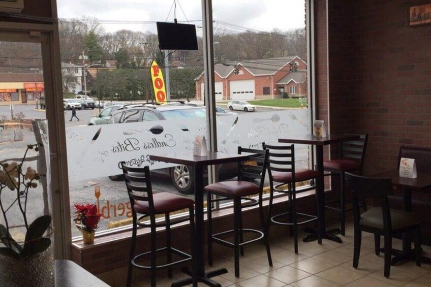 A restaurant interior with a view of a parking lot and a 'FOOD' sign outside. 2
