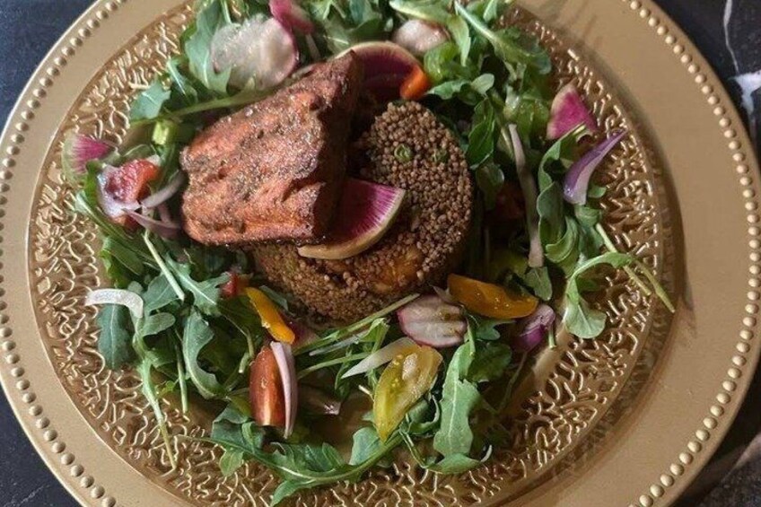 A plate with a meat dish, greens, and radishes. 5