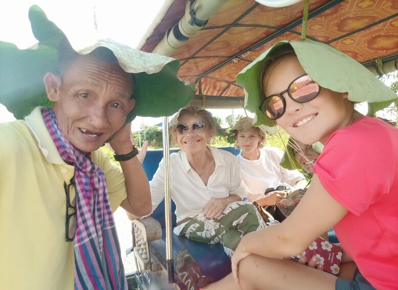 A group of people on a boat with a canopy overhead. 1