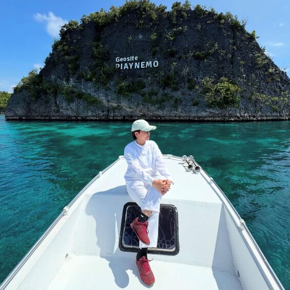 Una persona en un bote con una isla rocosa al fondo, identificada como 'Geosite DIAYNEMO'. 4
