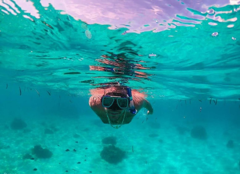 Une personne nageant sous l’eau avec un tuba et des palmes. 1