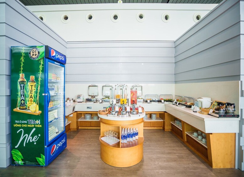 A cafe with a Pepsi refrigerator, a counter with tea and coffee, and a display of bottled water. 4